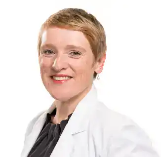Portrait Foto von Simone Fischer, Landes-Behinderten·​beauftragte. Frau mit kurzen blonden Haaren lächelt in die Kamera. Sie hat eine schwarze Bluse und einen weißen Blazer an.